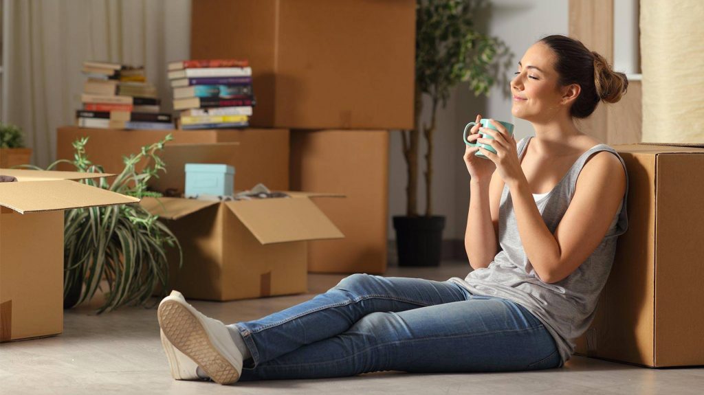 Une jeune femme heureuse d'avoir emménagé dans son logement neuf