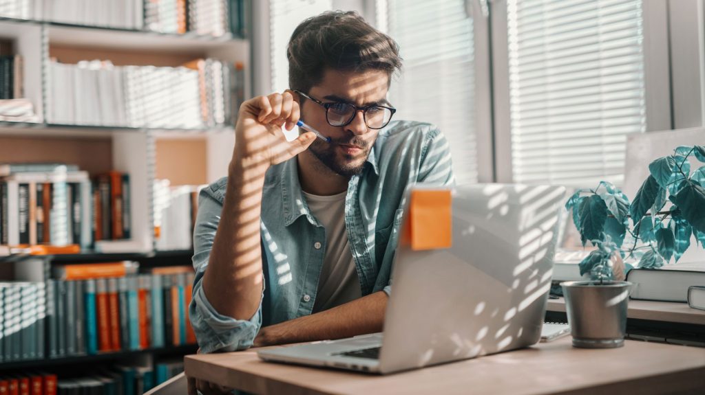 Jeune homme concentré sur un ordinaire