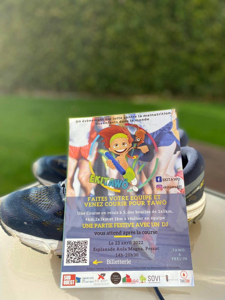 Un flyer posé sur une paire de basket à l'extérieur